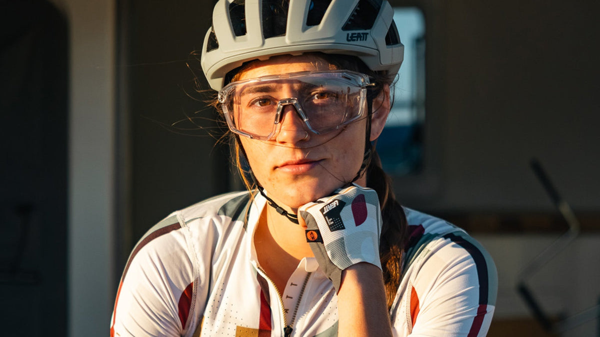 Person wearing a helmet and cycling sunglasses with a blurred background