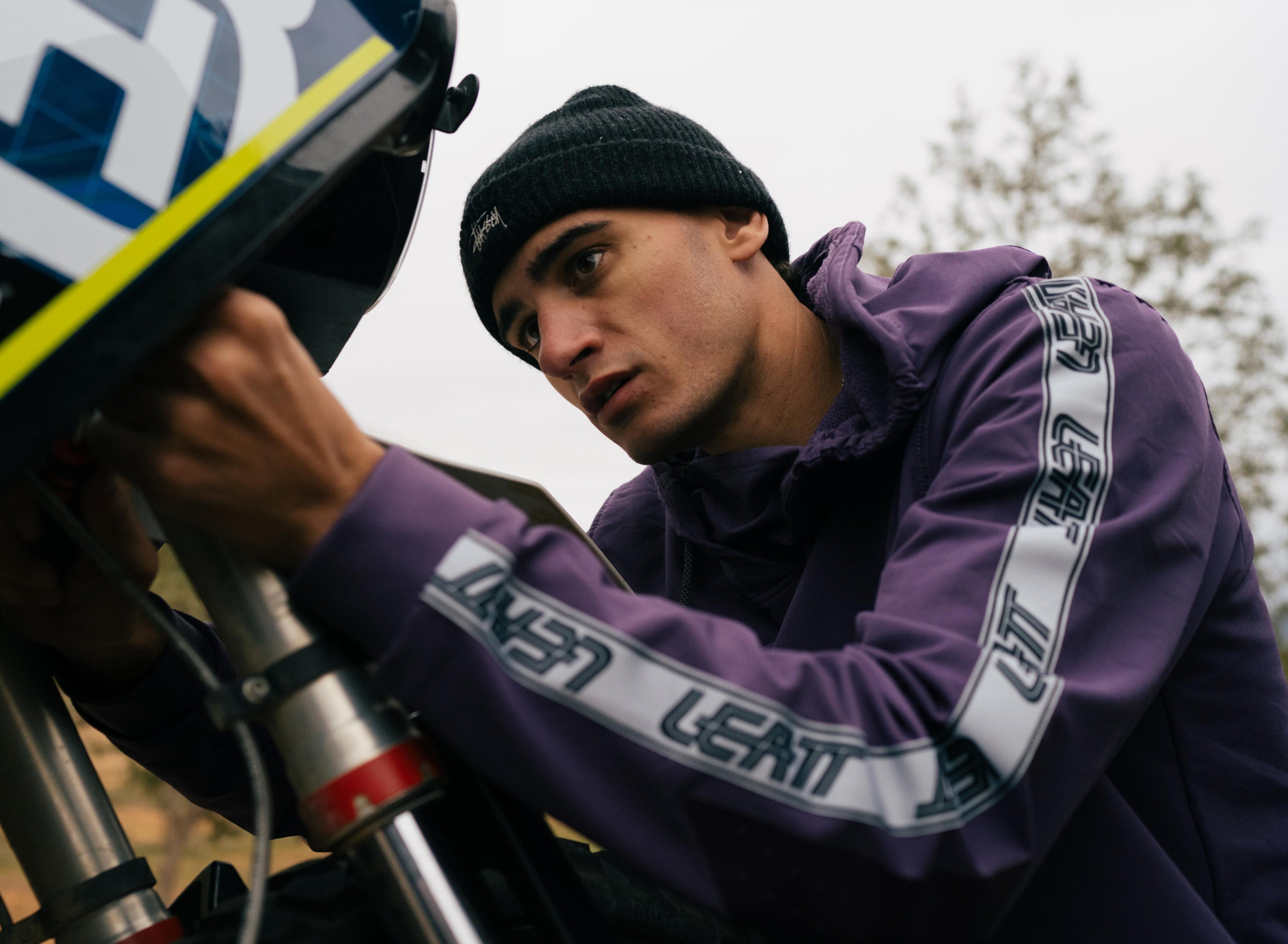 Man fixing motobike in a hoodie