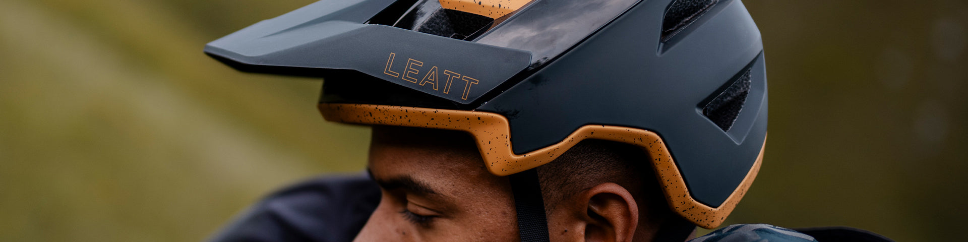 Person wearing a Leatt helmet with a blurred natural background